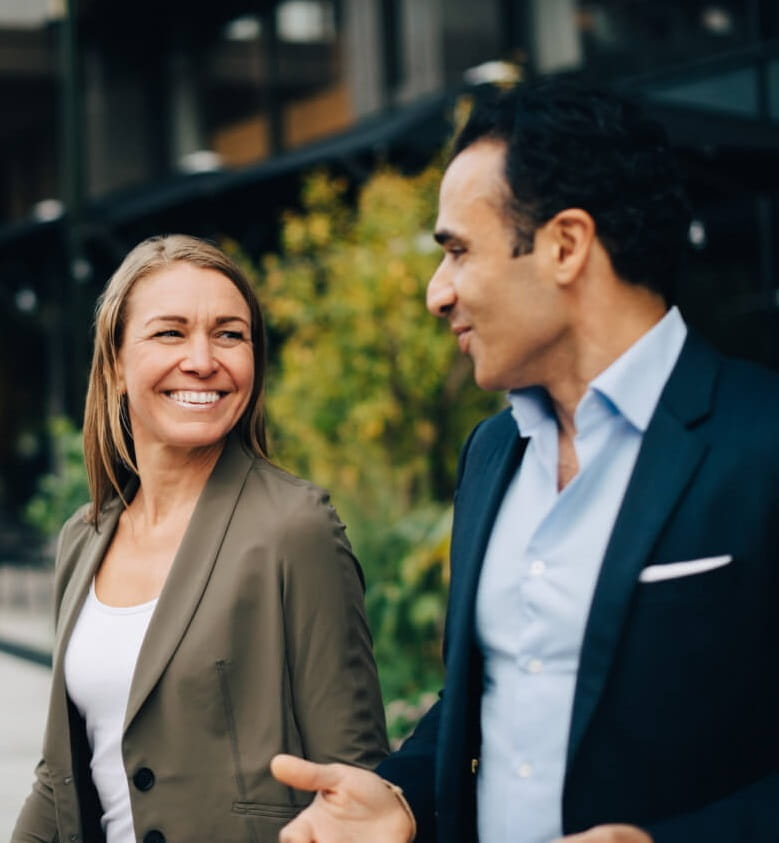 An advisor and investor chat outside an office building