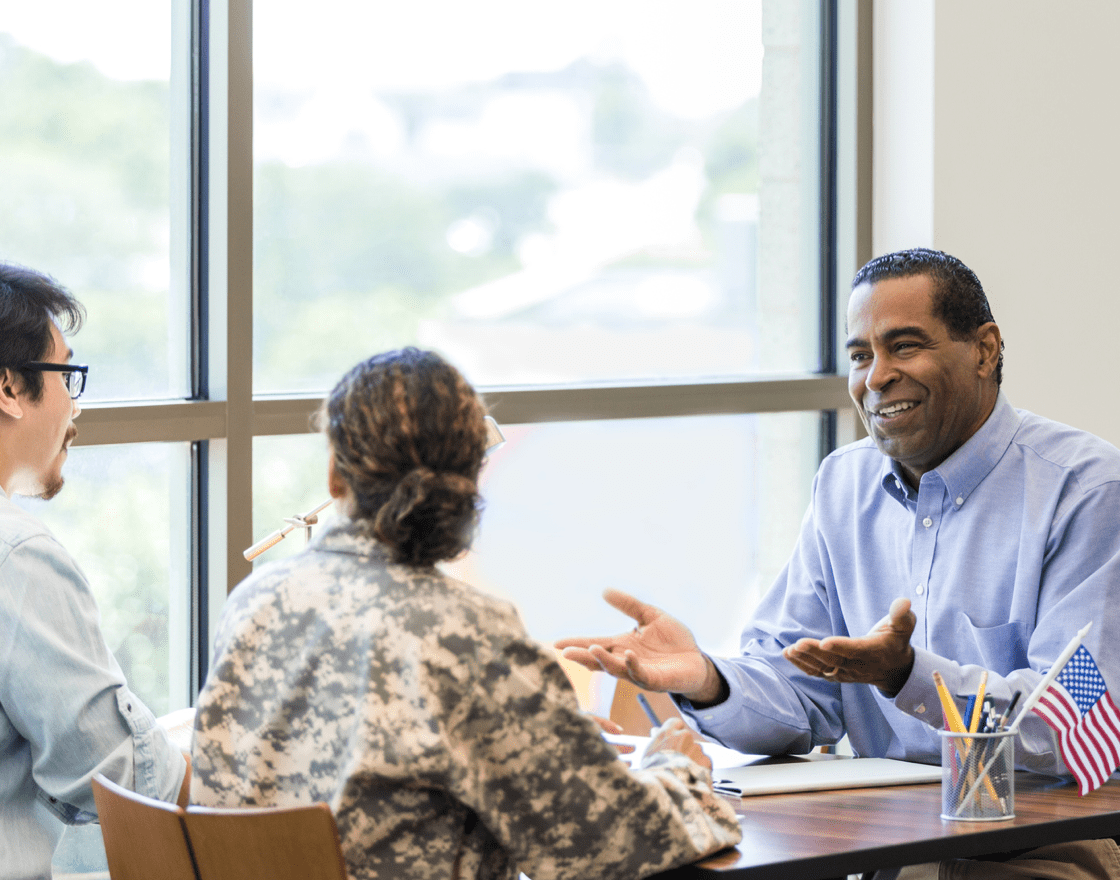 Broker speaking to 2 military members in an office