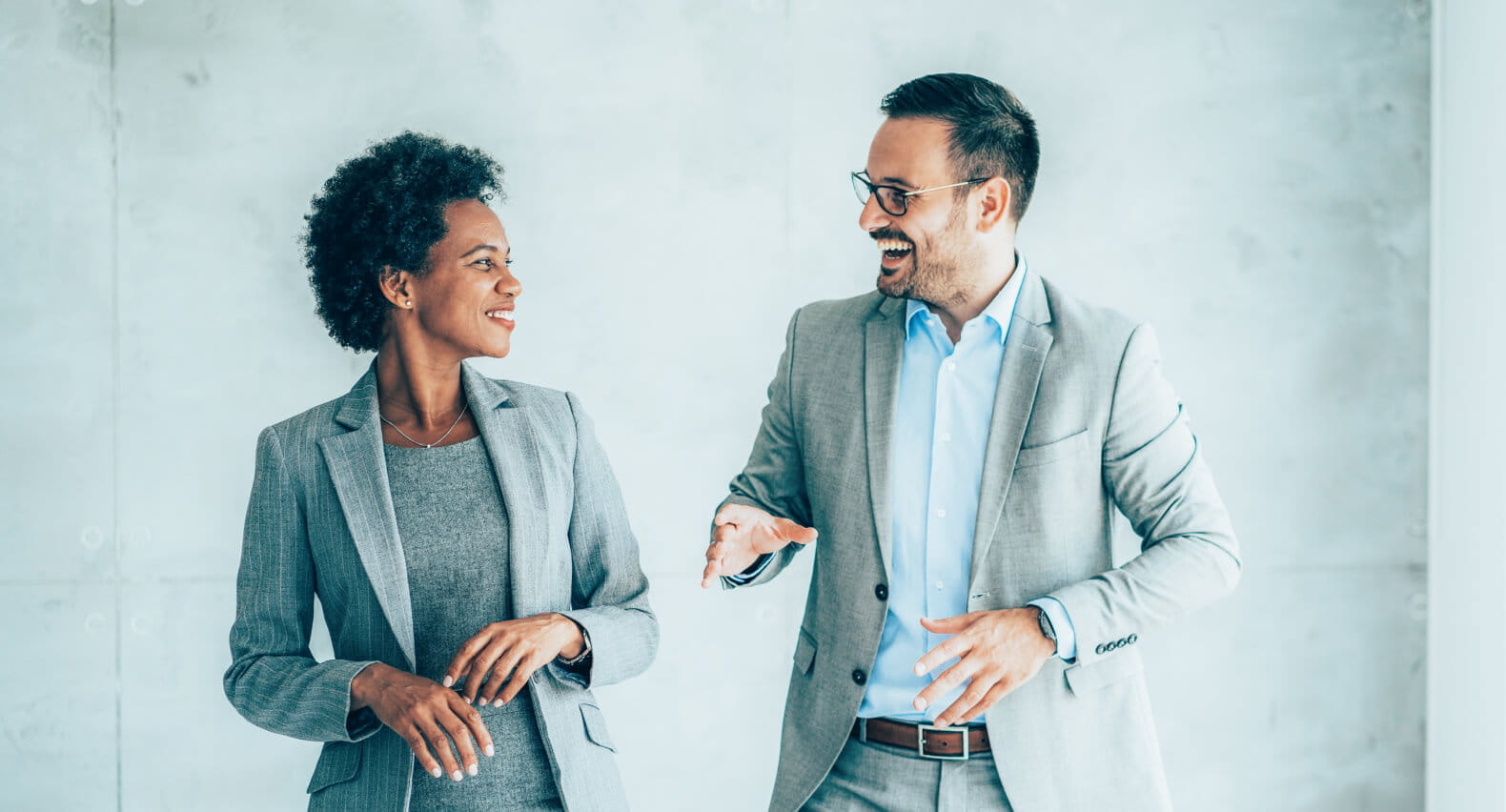 Two coworkers talking and laughing together.