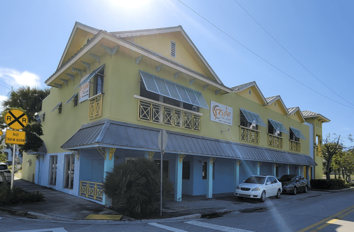 Exterior view of yellow building, the sky and parking areas.